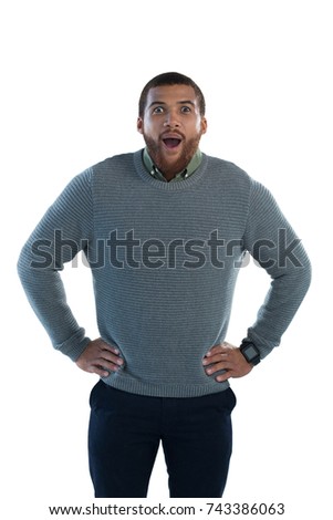 Portrait of man standing with hand on hips against white background