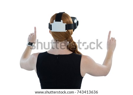 Rear view of female executive using virtual reality headset
