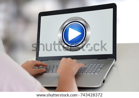 Woman using a laptop with play concept on the screen