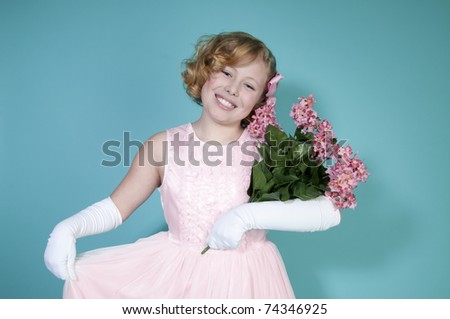 Little girl smiling holding bouquet of pink flowers
