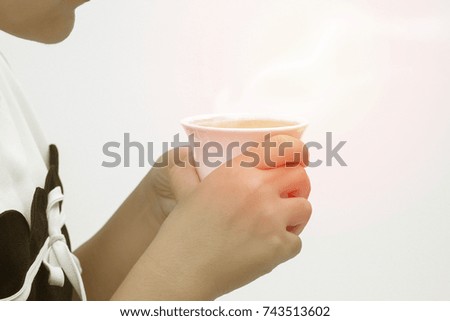 Side image of a woman holding a cup of hot coffee and steam.Relaxation with coffee.In orange light means morning sunshine, freshness.