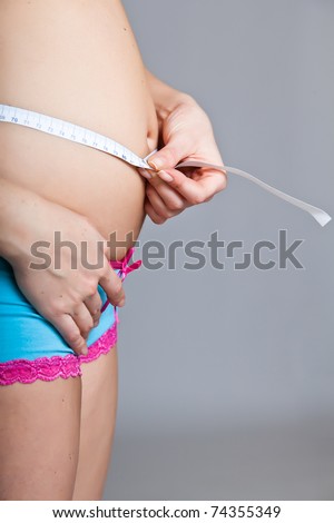 Pregnant woman belly with measure