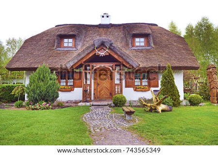 Poland, country house with straw roof and garden in front of home. Royalty-Free Stock Photo #743565349