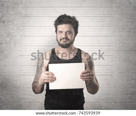 Gangster in front of a wall with table on his hand.