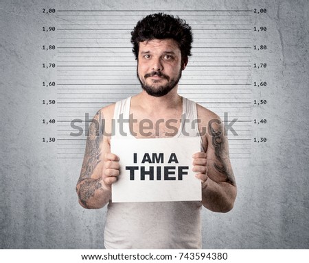 Caugth offender in front of a wall with table in his hand.
