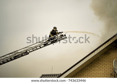 A firefighter puts out a burning building with height extension ladders.