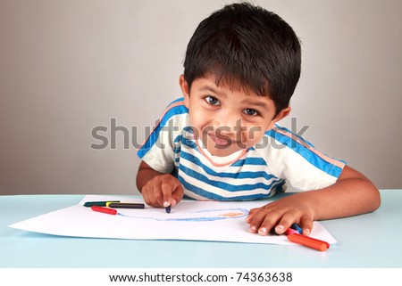 A boy looking while painting on a white paper Royalty-Free Stock Photo #74363638
