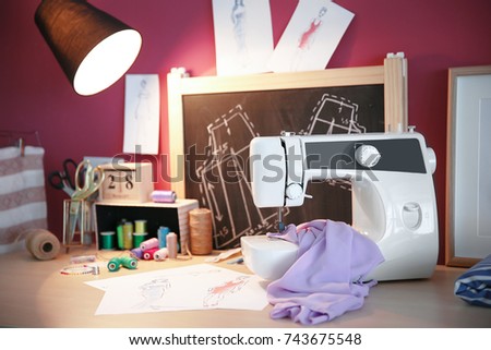 Modern sewing machine and tailor accessories on table
