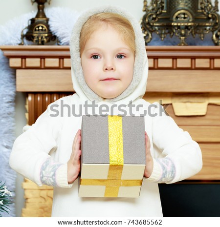 A sweet little four year old girl with a gift in her hands on Christmas Eve.