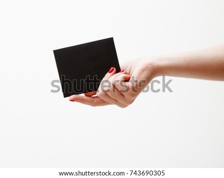 Flat lay, top view. Beauty and fashion concept. Beautiful female hands with red manicure. Minimal style. Minimalist photography. Composition with girl's hand holding discount card on white background