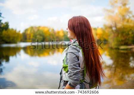 Image of smiling woman with backpack and bicycle helmet