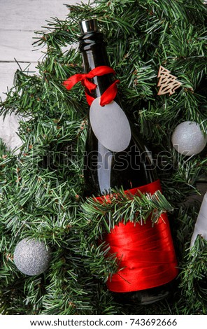 Photo of spruce branches with bottle of wine, blank greeting card