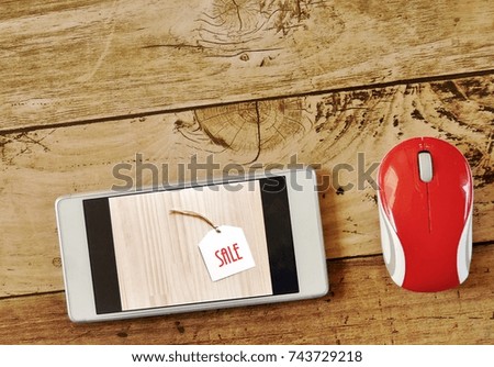 Online shopping over smartphone via internet shopping  concept  - photo of screen showing Sale Tag on on wooden table and red mouse  with  wooden background for Sale / seasonal promotion Event