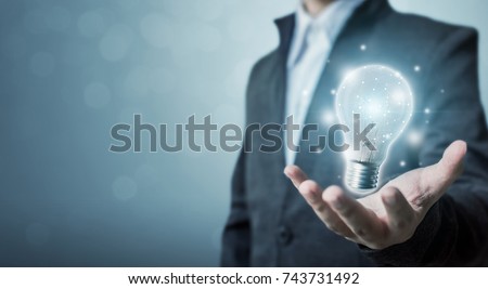 The power of creativity, technology, innovation or new business to success in the future concept, Businessman holding light bulb Royalty-Free Stock Photo #743731492