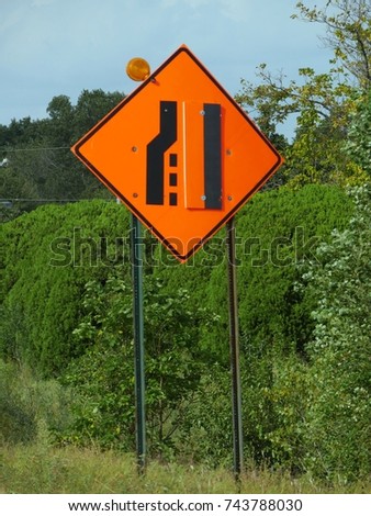 Road sign warning drivers that the lane will end and merge. This is usually posted on the road where construction or road repair is in progress.