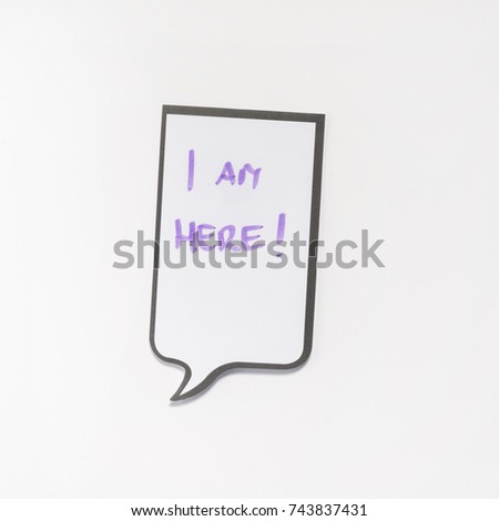 a white memo pad with the shape of a comic with the inscription "I am here"	