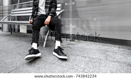 man is sitting on a bench. Urban photo. Look book. Hype sneakers background. Best