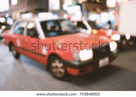 abstract blur and defocused urban red taxi at night in Hong Kong for background, old film look effect