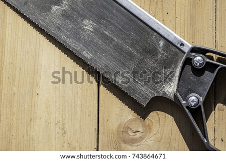 Hand saw pictured close up on a wood background