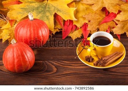 Autumn banner with yellow leaves, pumpkins and cup of coffee on wooden textured backdrop. Fall background for thanksgiving day or seasonal sales card or flyer.