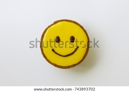 Yellow smile face cup cake on white background.