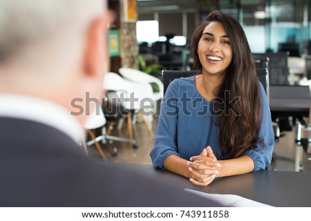 Young female candidate laughing at job interview Royalty-Free Stock Photo #743911858