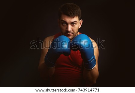 man in boxing gloves over black background