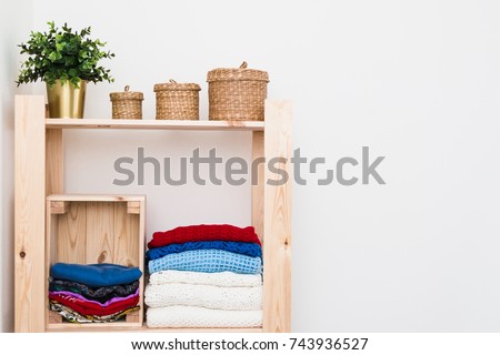 Order in the closet. Capsule wardrobe. A rack with women's clothing, neatly folded. Knitted sweaters and sweaters, jeans and pants, fashion shoes. Royalty-Free Stock Photo #743936527