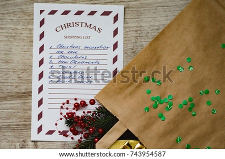 Christmas shopping list on a wooden plank background.