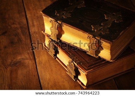 Image of antique books, with brass clasps on old wooden table. fantasy medieval period and religious concept