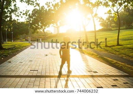 silhouette of a kid on sunset at garden