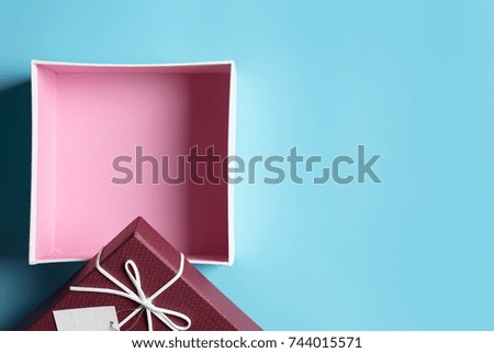Red gift box, ribbon bundle, placed on a blue background.