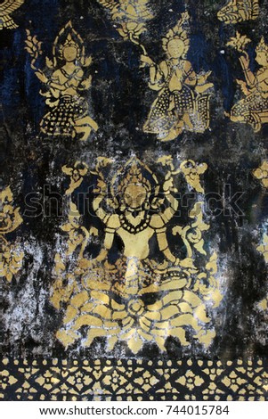 Detail of the Buddhist temple decoration, gold leaf goddesses and figures on a black background, at Wat Xieng Thong, Luang Prabang, Laos.