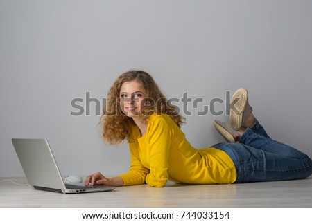 young woman with laptop on gray background