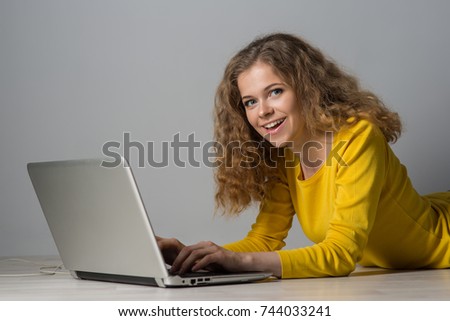 young woman with laptop on gray background