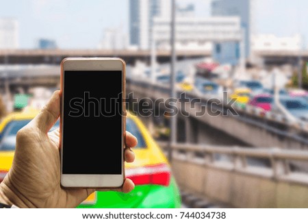 Man hand holding smart phone,cellphone on city traffic jam in morning blurred background.copy space.