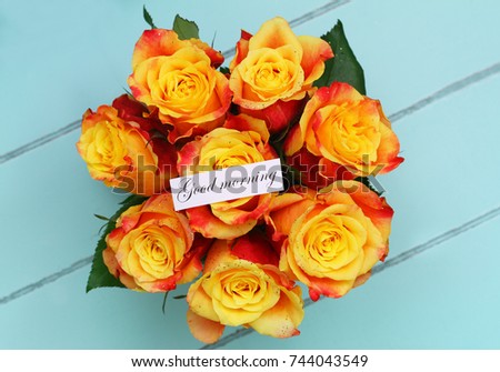 Good morning card with colorful rose bouquet on blue wooden surface
