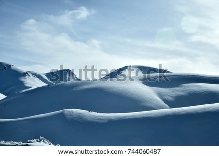   Light and shadow of snow capped mountain under blue sky. Tajikistan