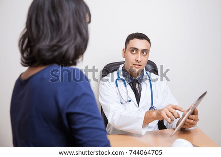  doctor talking with female patient in doctors office.