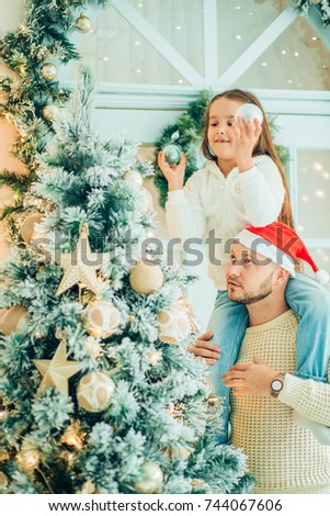 Dad and daughter decorate Christmas tree indoors. morning before Xmas. Portrait loving family close up.