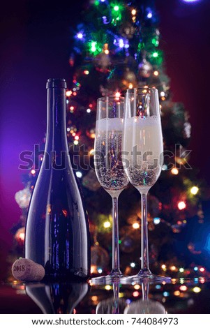 close up view of champagne bottle with flutes  on color back