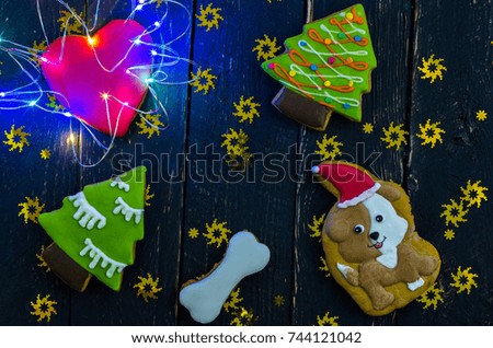 Christmas composition with gingerbread and a colorful garland. Dark background.