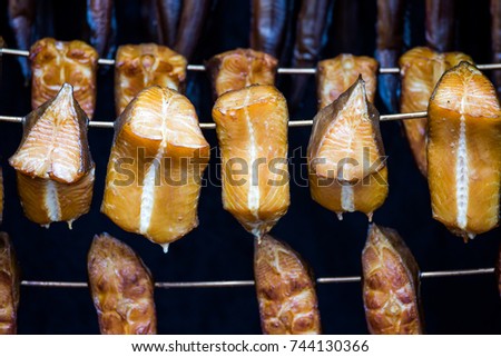 smoked pieces of halibut hanging in a smoking oven