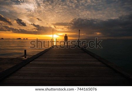 Young man standing at wood bridge into the sea