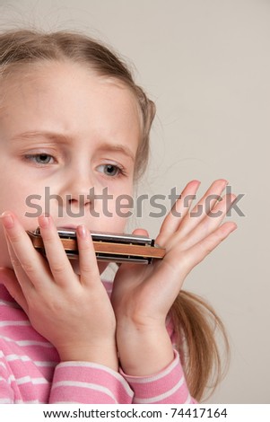 Young girl play blues harmonica