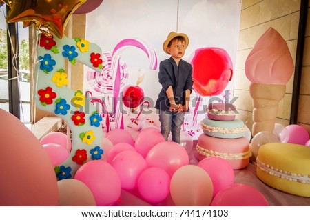 Cute and elegant Caucasian child boy feeling estranged at somebody's birthday party. Loneliness concept stock image.