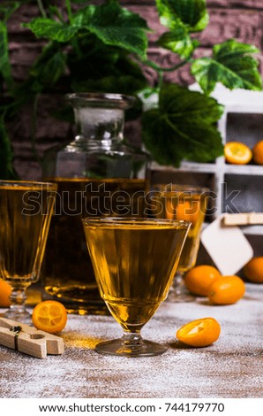 Transparent orange drink in glass on wooden background. Selective focus.