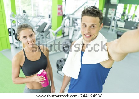 The sportsman and sportswoman make a selfie in the sport center