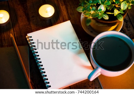 Books and pencils are placed on the table, decorated with tiny beautiful candles to add color to the picture, and a coffee mug placed next to it.
