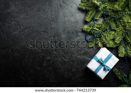 Christmas background with decorations, fir tree and gift boxes on black background, top view with copy space